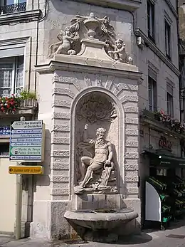 Fontaine adossée ornée de bossages vermiculés encadrant une niche.