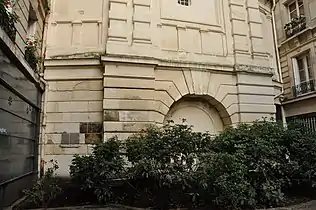 Partie basse de la fontaine, cachée derrière un épais feuillage.