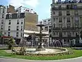 La fontaine au centre de la place.