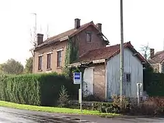 L'ancienne gare en 2021, transformée en habitation, et l'arrêt d'autocars.