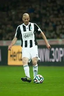 Portrait, de face, d'un joueur de football portant un maillot rayé noir et blanc