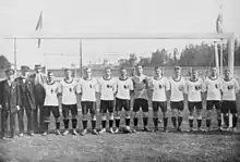 Photographie en noir et blanc d'une équipe de football : les joueurs sont debouts, vu de face.