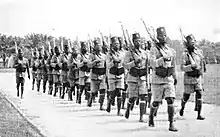 Photo d'une colonne de soldats africains avec fusils