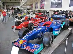 Voitures de Formule 1 exposées au musée, avec, au premier plan, la Sauber Petronas C18 de Jean Alesi en 1999.