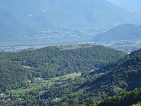 Vue des rochers de Comboire et de son fort depuis la tour sans Venin au nord-ouest ; en arrière-plan la plaine de Reymure, le Petit Brion et le pied du massif du Taillefer.