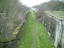 Allée d'herbe entre deux murs de pierre