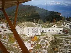 Vue d'avion sur un fort suspendu à une crête rocheuse.