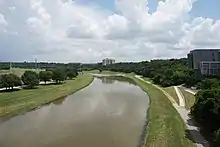 Vue d'une rivière bordée de pelouse et d'arbres