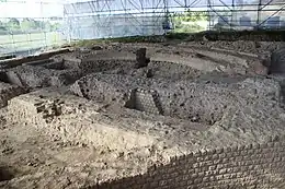 Photographie d'un chantier de fouilles archéologiques protégé par une grande verrière.