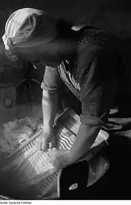 Femme allemande utilisant vers 1947 une planche à laver pour la lessive manuelle, ce qui est la fonction originelle de cet objet.