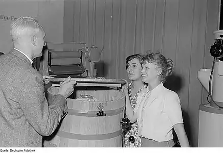 Trois personnes sur un stand avec des appareils électroménagers, Foire d'automne de Leipzig (en) 1953.