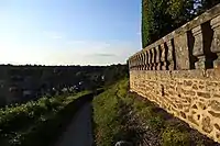 La balustrade de la Place aux Arbres et un sentier descendant vers la Place Leroux.