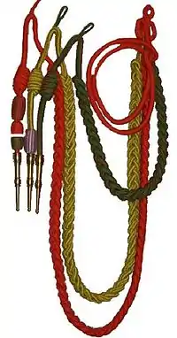 Les fourragères du RICM : fourragère double aux couleurs de la Légion d’honneur et de la Croix de guerre 1914-1918 et fourragère aux couleurs de la médaille militaire TOE.