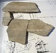 Fragments du plan d'une ville gravés dans la pierre, reportés sur le même plan en papier.
