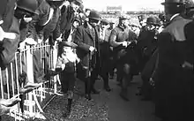 Photographie noir et blanc d'un homme au milieu de la foule.