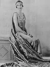 photographie noir et blanc : portrait de femme assise en robe, les bras nus