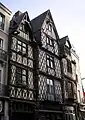  Photographie d'un ensemble de trois maisons à colombages et pignons.