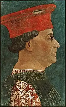 Portrait de profil d'un homme tourné vers la droite richement habillé, portant un haut couvre chef rouge d'où dépassent sur l'arrière des cheveux noirs boucles.