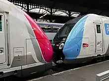 Deux rames Z 50000 en gare de Paris-Saint-Lazare, à gauche en livrée Carmillon, à droite en livrée Île-de-France Mobilités.