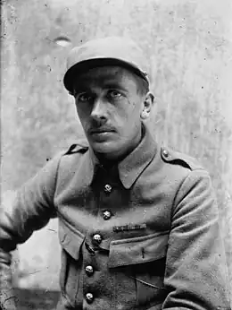 Photographie en noir et blanc d'un homme assis en tenue de soldat.