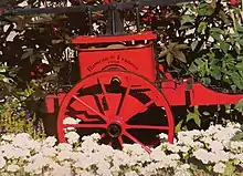 Une charrette rouge et fleurie de 1930 dans le hameau de Francoz.