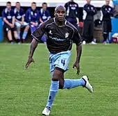 un joueur de football en mouvement cherchant le ballon des yeux