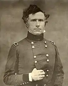 Photographie d'un homme en uniforme aux cheveux bouclés