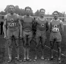 Photographie en noir et blanc de quatre athlètes côte à côte.