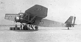 Photo d'un avion posé sur un terrain, de profil, avec cocardes tricolores.