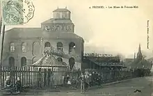 Carte postale ancienne montrant la fosse Soult n° 1 des mines de Thivencelle à Fresnes-sur-Escaut, avec son bâtiment en briques, et le sommet de son chevalement recouvert de bois. L'église est reconnaissable en arrière-plan, à droite.