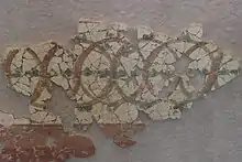 Photographie d'une fresque antique à motifs de cercles entrelacés.
