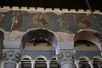 Chapiteaux, mosaïques, et fresques du XIIIe siècle sur le mur.