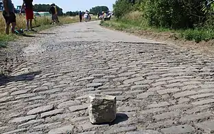 Un pavé échappé avant le passage des coureurs.