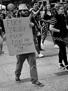 Manifestant tenant une pancarte sur laquelle est écrit « Fuck Trump ».