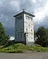 Une Führungsstelle ou Kommandoturm, une tour de 6 m possédant un poste d'observation et un centre de commandement
