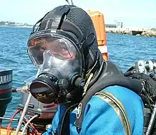 Un plongeur équipé d'un masque intégral de plongée, autorisant l'installation d'un système de communication.