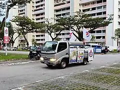 Véhicule de campagne du Parti d'action populaire pour les élections de juillet 2020 à Singapour. Sur le lampadaire se trouvent des affiches du Parti d'action populaire et du Parti populaire.