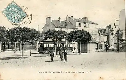 Tramway à l'arrêt devant l'église d'Épinay, devant son aubette.