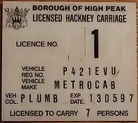 Plaque de licence de taxi au Royaume-Uni dans les années 1990.