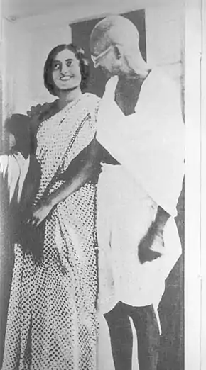 Photographie noir et blanc du Mahatma Gandhi, avec un pagne, et Indira Gandhi, en robe, vers 1930.