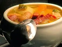 Photographie en couleurs d'une soupe avec des légumes.
