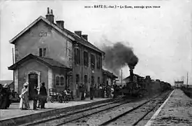 Carte postale ancienne montrant l'entrée en gare d'une locomotive à vapeur.