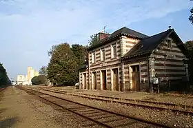 Photographie représentant au premier plan une gare, au second plan une usine.