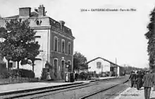 Deux voies et deux quais avec à gauche le bâtiment voyageurs et une halle à marchandises