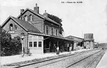 L'intérieur de la gare, avec les voies, le bâtiment voyageurs, la halle à marchandises et le château d'eau.