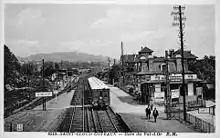 Carte postale en noir et blanc représentant une gare et un embranchement.