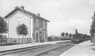 Vue d'un petit bâtiment ferroviaire sur une carte postale ancienne noir et blanc.