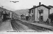 vue de la gare PLM avec les des deux voies, deux quais : l'un avec un abri et l'autre avec le bâtiment voyageurs et au fond un château d'eau.