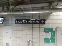 Quai de la gare avec le panneau annonçant l'arrêt « Bussy-Saint-Georges ».