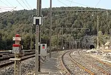 La sortie de la gare de Cassis vers Marseille. À gauche la ligne, à droite les voies de desserte de l'embranchement particulier Lafarge et en arrière-plan le tunnel du Mussuguet